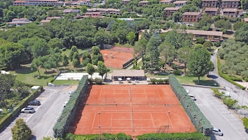 Un campo da tennis circondato da alberi e edifici.