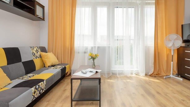 Una sala de estar moderna con un sofá, una mesa de centro y un mueble para la televisión.