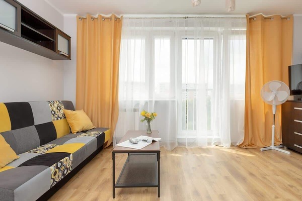 The living area features a sleek coffee table and a flat-screen television.