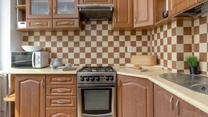 Una cocina con armarios de madera, microondas, tostadora, estufa y salpicadero a cuadros.
