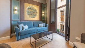 Una sala de estar moderna con un sofá azul, una mesa de centro y una gran obra de arte circular en la pared.