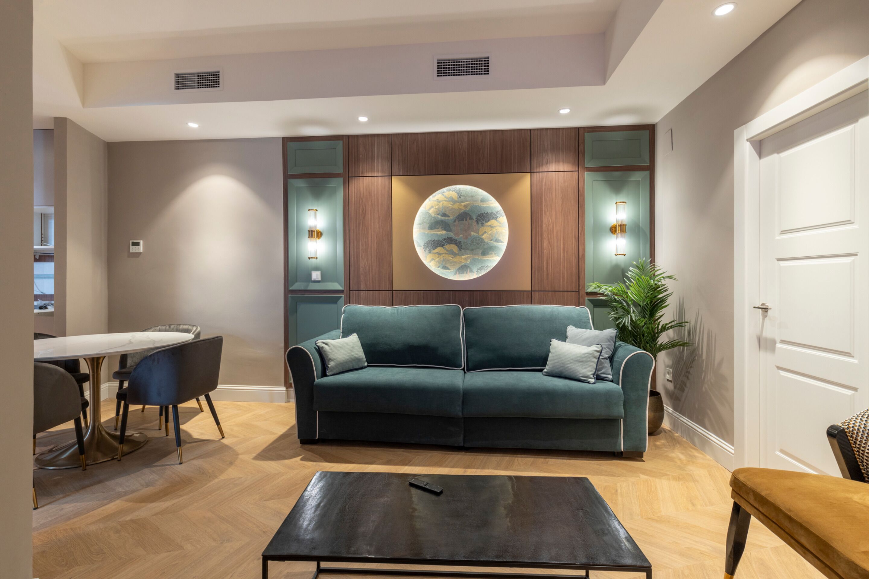 Un salon moderne comprenant un canapé, une table basse et un coin repas avec une table et des chaises.