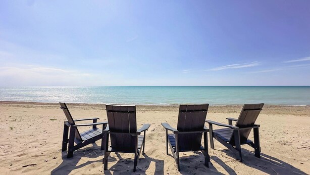 Two wooden beach chairs facing a beach with a clear view of the ocean. - Huron Shores, Hot Tub, Lakefront (Point Clark)