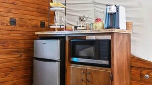 Une petite cuisine équipée comprenant un réfrigérateur Galanz, un four à micro-ondes et un meuble en bois.