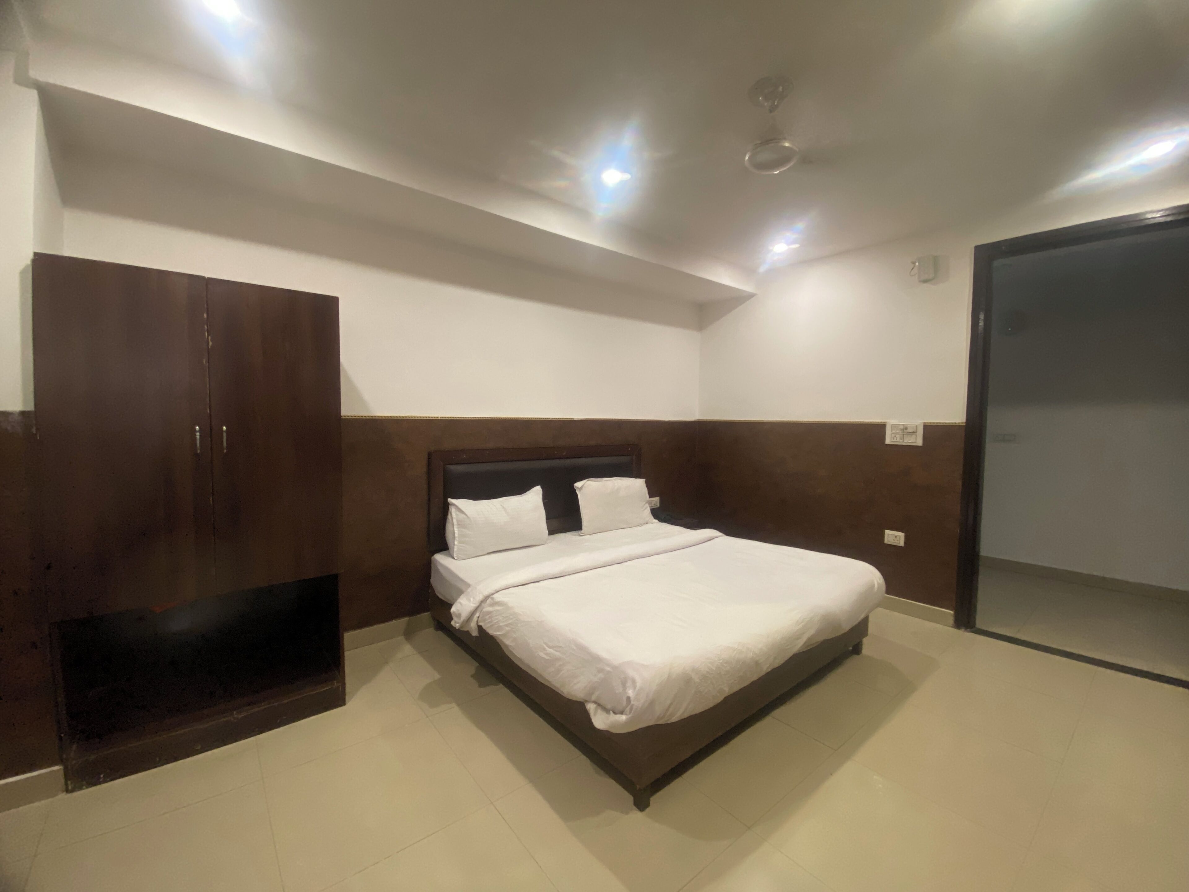 A bedroom with a bed, a wardrobe, and a door.