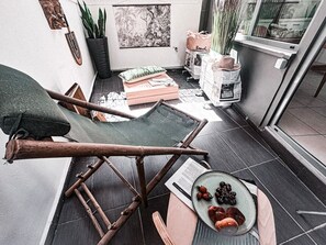A compact living space with a foldable chair, a small table with a plate of food, and a potted plant. - Urban Brown by Domisi with private Jacuzzi (Rethymno)