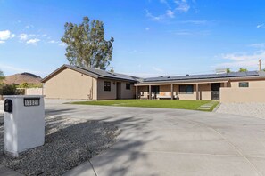 A modern two-story house with a covered patio area, a driveway, and a mailbox with the number 13829.