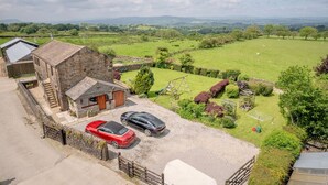 A stone house with a carport, a red car, and a black car parked in front. - Higher Gills Farm, Stunning Views, 4 bedroom (Clitheroe)