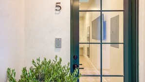 A modern hotel entrance with a glass door, a keypad lock, and a number '5' sign. - Casa De La Vina Studio 5 (Santa Barbara)