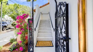 A staircase leading to a white building with a black wrought iron gate.