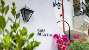 Un bâtiment blanc sur lequel on peut lire l’inscription « CASA DE LA VINA », et une lanterne noire.