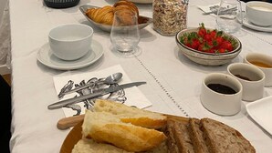 A breakfast table set with croissants, fruit, strawberries, and coffee. - Chambre D'hôtes En Apar-té en Fond de Jardin Calme Relaxation Piscine (Toulouse)