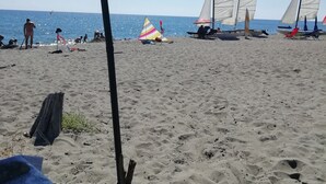 A beach with sailboats, a clear sky, and a sandy shore. - Bright and friendly bungalow in a naturist beach vacation village in Corsica (Linguizzetta)