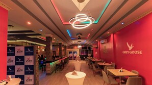 Un interior de restaurante con barra, mesas y sillas.