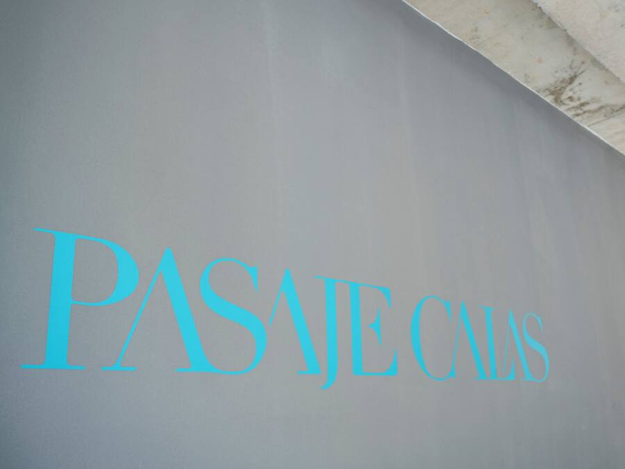 A sign with the text "PASAJES CALAS" in blue letters on a grey background.