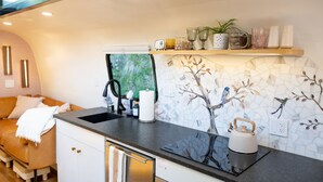 A compact kitchen with a modern design, featuring a sink, kettle, and a decorative backsplash. - Creekside Fern in Pisgah Forest (Pisgah Forest)