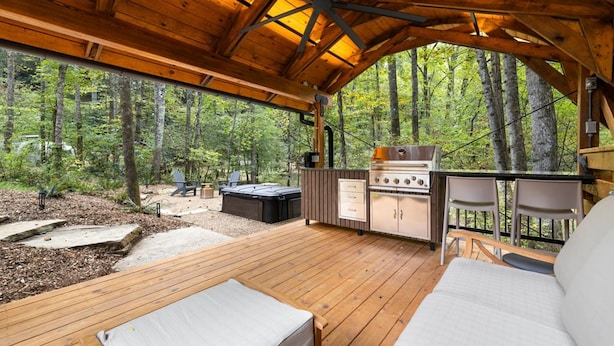A covered outdoor deck with a wooden ceiling, a grill, and seating. - Silver Fern in Pisgah Forest (Pisgah Forest)