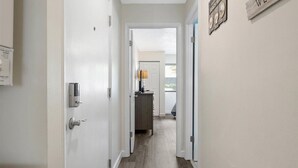 A hallway with a door leading to a room, a welcome sign, and a view of the outdoors. - Close to the Boardwalk, Jolly Roger Amusement Park With a Pool! (Ocean City)