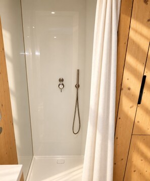 A shower enclosure with a glass door, a handheld showerhead, and a control panel. - Kalmdown Cabin - Antwerp (Wuustwezel)