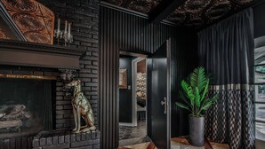 Een modern interieur met een open haard, een potplant en een uitzicht door een deur.