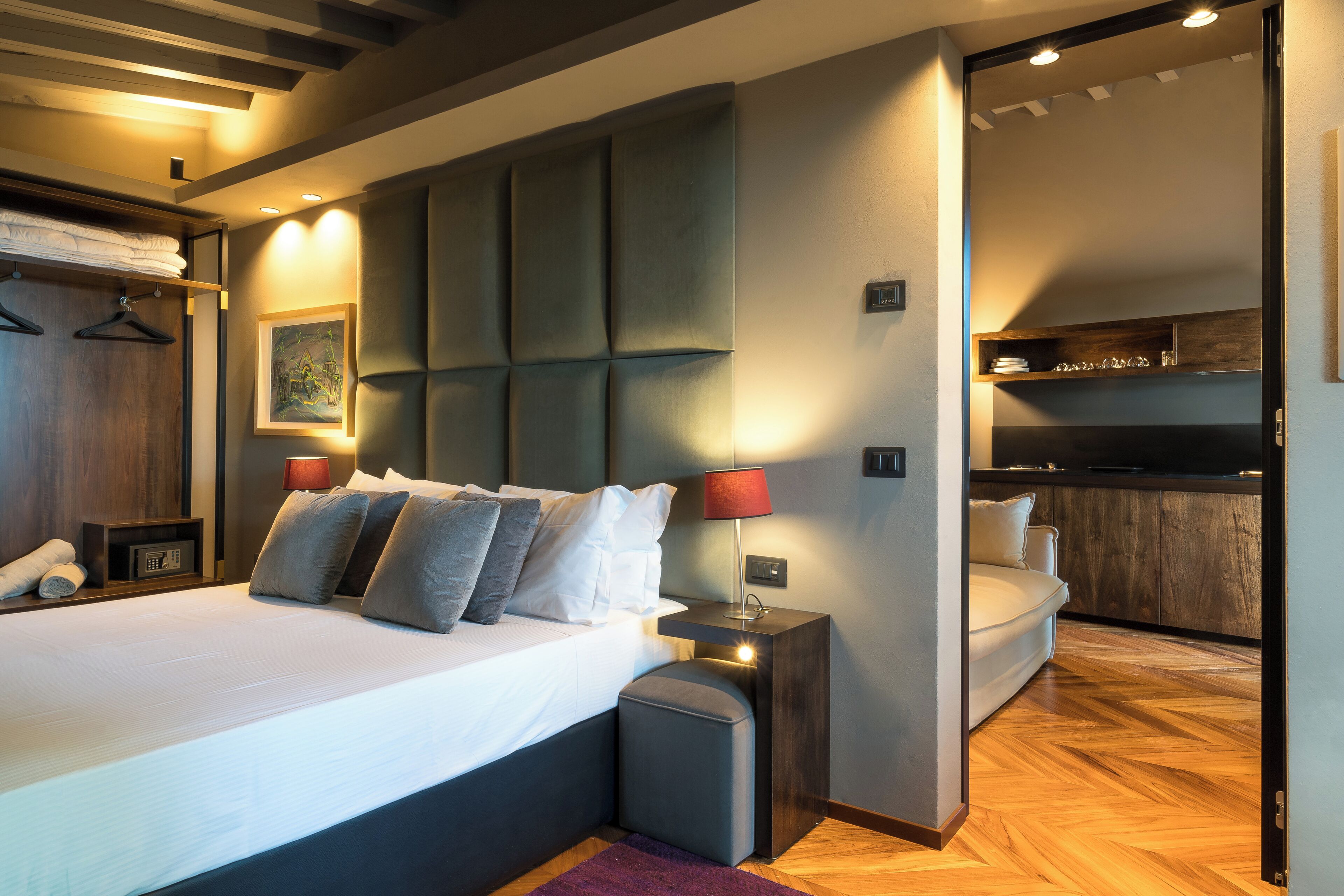 Un dormitorio moderno con una cama grande, mesitas de noche, un armario y un banco empotrado.