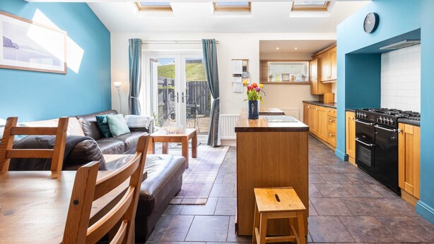 Una cocina moderna con una isla central, muebles de madera y vistas al exterior.