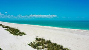 A beach with white sand and clear turquoise water. - Island time. 10 min walk to beach, heated pool, wide water views.  Pet friendly! (Sanibel)