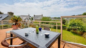 A patio with a table set for two, a potted plant, and a view of the surrounding neighborhood. - House for 6 with a view of the port of Dahouët (Pléneuf-Val-André)