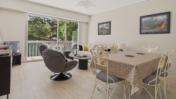 A dining area with a table and chairs, a sofa, and a view of the outdoors through a sliding door. - Appartment for 4 in the heart of La Baule (La Baule-Escoublac)