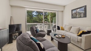 A modern living room with a sofa, armchairs, a coffee table, and a TV. - Appartment for 4 in the heart of La Baule (La Baule-Escoublac)