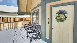 A covered outdoor seating area with Adirondack chairs and a door with a welcome wreath. - 7 Mi to Big Bear Lake: A-frame Home w/ Deck! (Sugarloaf)