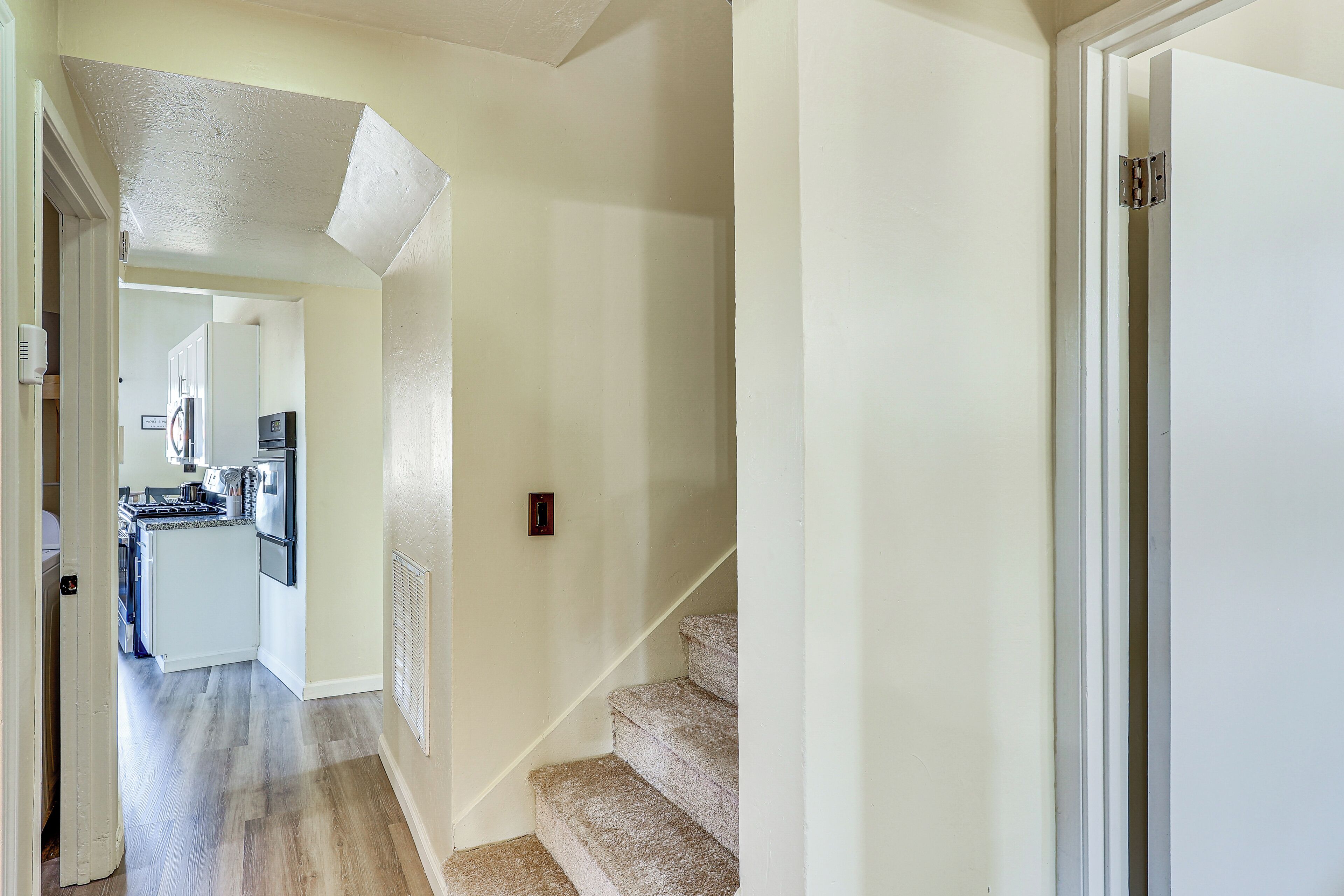 A hallway leading to a kitchen with a built-in stove and refrigerator.