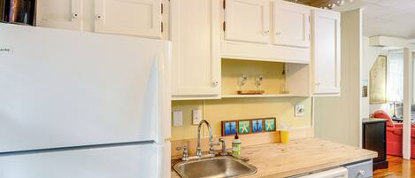 A kitchen with white cabinets, a stainless steel sink, and a coffee maker.