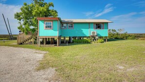 A turquoise house with a red roof, a wooden deck, and a large tree in the background. - Waterfront Perry Home: Rooftop Deck, Pets Welcome! (Perry)