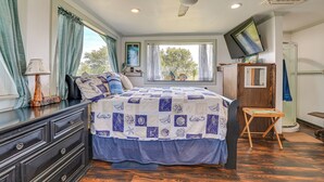 A bedroom with a bed, a dresser, a television, and a window with curtains. - Waterfront Perry Home: Rooftop Deck, Pets Welcome! (Perry)