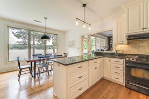 Una cocina moderna con una isla grande, armarios blancos y horno empotrado.