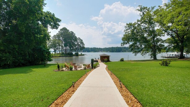A pathway leading to a lakeside gazebo with a view of the lake and trees.