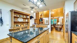 A spacious kitchen with wooden cabinets, a granite countertop, and a built-in refrigerator.