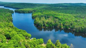 A river winding through a densely forested area with boats on the water.