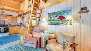 A cozy cabin interior with wooden walls, a dining area, and a living room featuring a sofa and armchair. - Denmark Waterfront Cabin w/ Dock & Charcoal Grill! (Denmark)