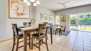 Un espace repas comprenant une table en bois, des chaises et un ventilateur de plafond.