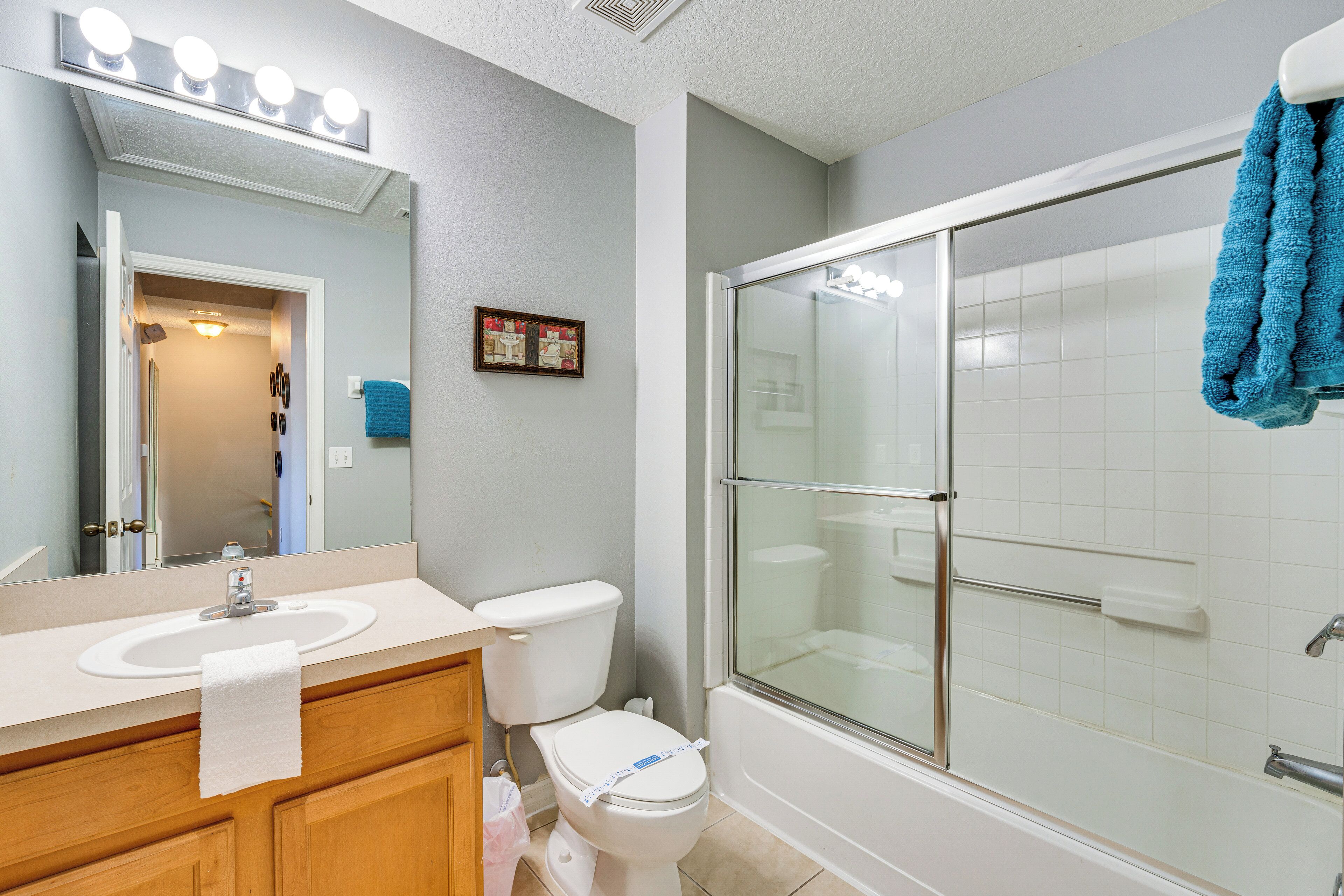 A bathroom with a sink, toilet, and glass-enclosed shower.