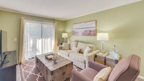 A living room with a sofa, a coffee table, a TV, and a lamp. - 1 Mi to Beach, Pool Access: Hilton Head Island Gem (Hilton Head Island)