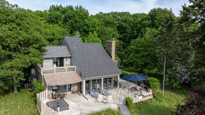 Een huis met twee verdiepingen, een terras, een overdekte patio en een pad naar de woning.