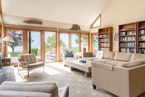 Relax in this stylish living room with a large sofa, coffee table, and comfortable armchair.