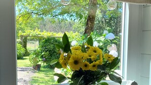 A kitchen with a window, a sink, and a vase with yellow flowers. - La Casita A de Naval in the Rías Baixas, Pontevedra (activities for customers)  (Pontevedra)