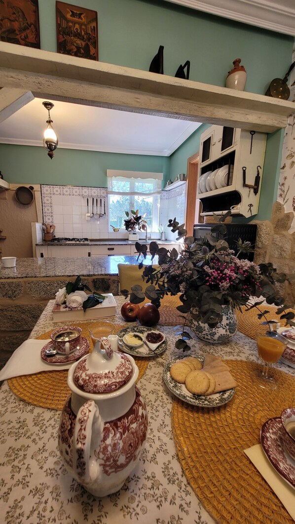 A dining area with a table set for a meal, featuring a variety of dishes and a centerpiece.