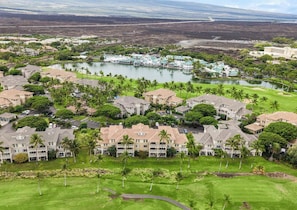 Un resort con varias construcciones, un campo de golf y un lago.