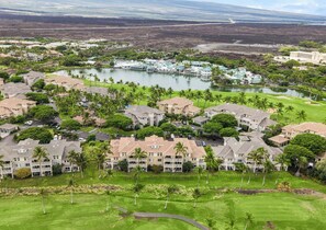 Un resort con varias construcciones, un campo de golf y un lago.