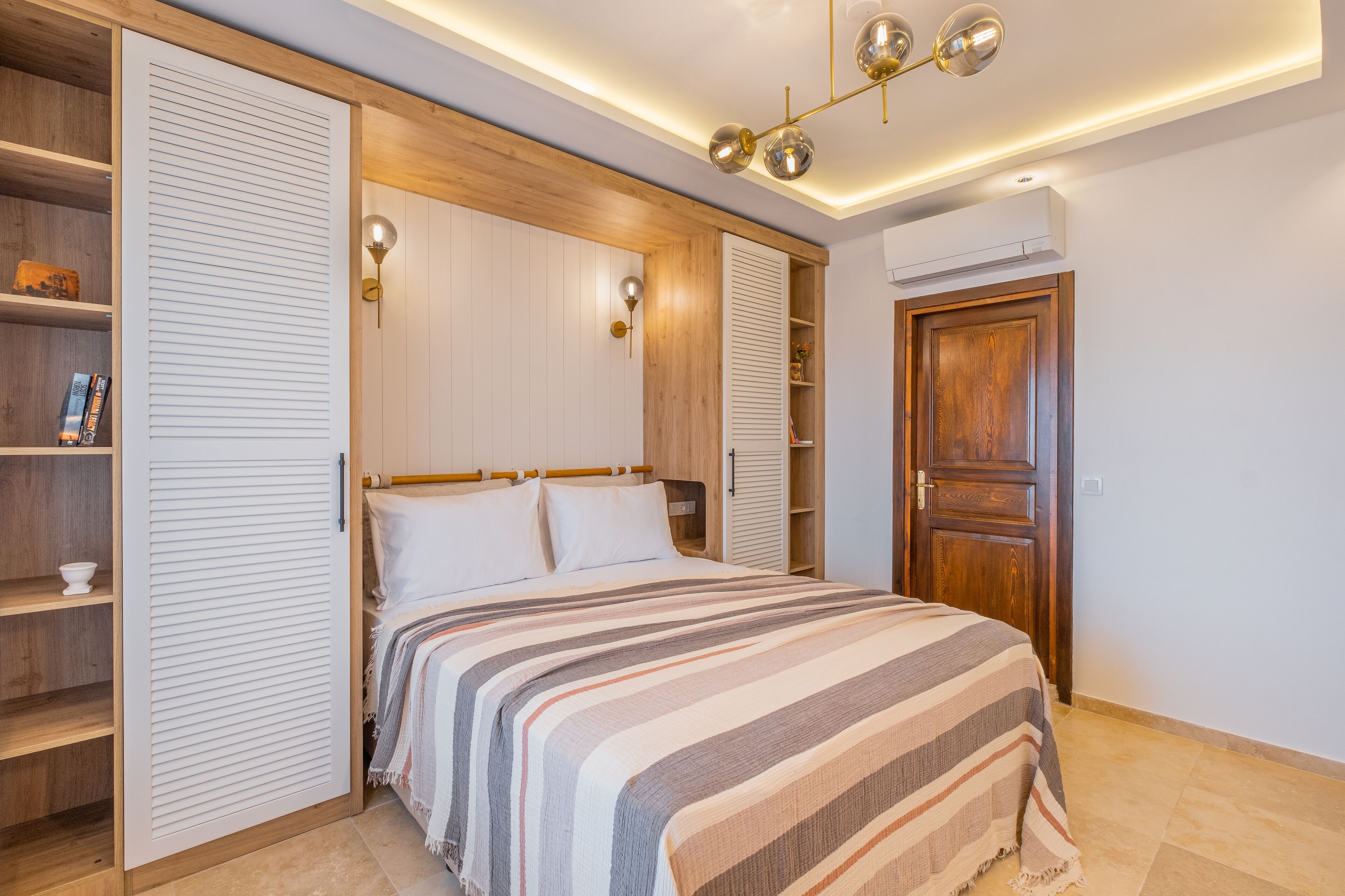 A bedroom with a bed, built-in wardrobe, and a ceiling light fixture.